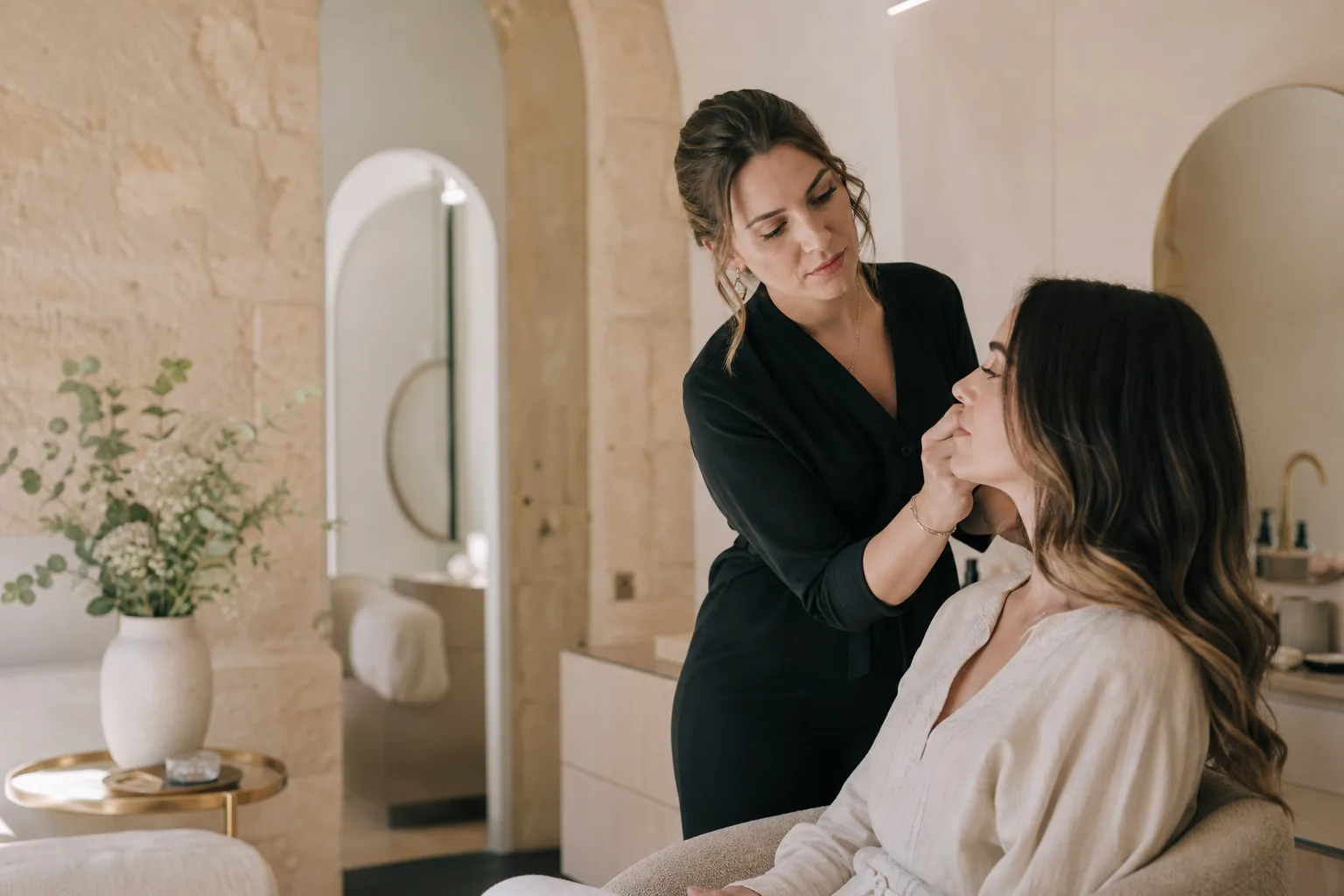 Professionnelle de la beauté préparant une cliente dans un studio élégant